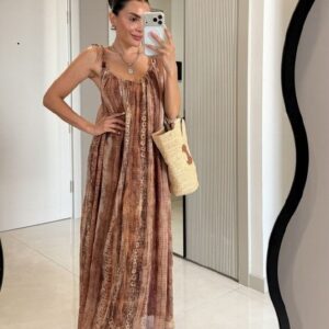 Angled front view of brown patterned tie-shoulder maxi dress, flowing skirt, woven tote and sandals. available for wholesale in Turkey.