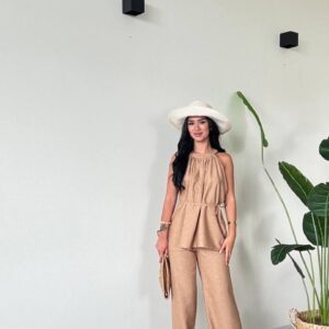 Ganzkörperbild eines beigen Tops mit gerafftem Ausschnitt und weiten Beinen Hose, ergänzt durch Strohhut und gewebte Clutch. - Großhandel Türkei