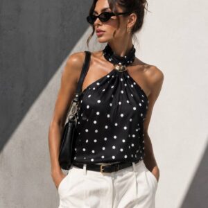 Close front view of black satin halter top with white polka dots and decorative gold ring at neckline. available for wholesale in Turkey.