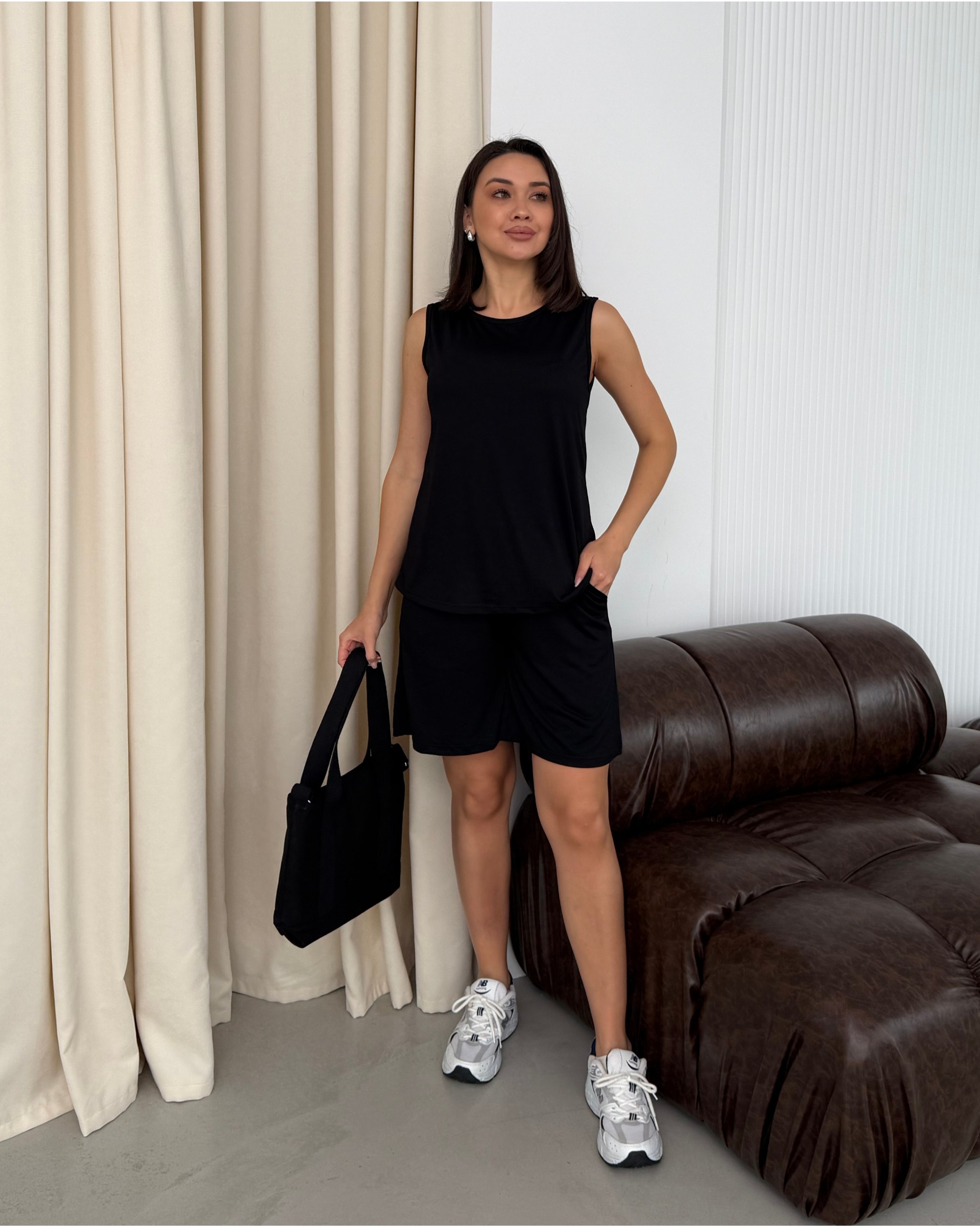 black-sleeveless-top-2938 Front view of a black sleeveless top with round neckline on model, smooth lightweight fabric drape