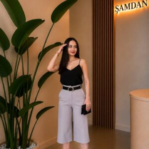 Modelo con camisola negra metida en culottes gris claro con cinturón ancho y tacones negros - Mayorista Turquía