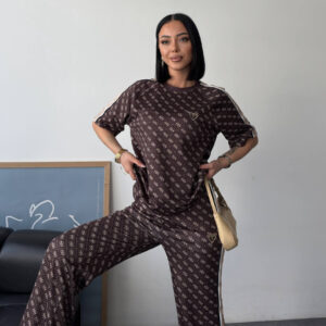Three-quarter view of chocolate monogram tee and flared pants with contrast tape on sleeves and side.