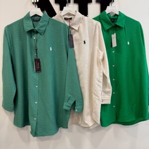 Three long-sleeve textured button-down shirts with collars in two shades of green and cream, small embroidered chest motif.