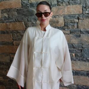 Ivory semi-sheer oversized tunic with mandarin collar, wide kimono sleeves, vertical tie panel and long tassel cords.