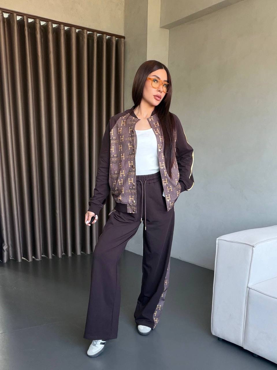 Two-piece brown tracksuit with monogram panels on bomber jacket and side-stripe wide-leg pants. Two-piece brown tracksuit with monogram panels on bomber jacket and side-stripe wide-leg pants.