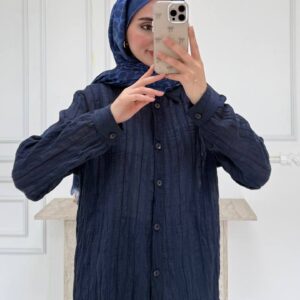 Vorderansicht einer marineblauen geknitterten Bluse mit Knopfleiste, haltransparente vertikale Struktur, Kragen und geradem Saum ueber Jeans.