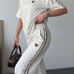 Full front view of navy patterned tee and wide-leg trousers with cream side stripe paired with sneakers.