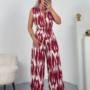 Front view of sleeveless wide-leg jumpsuit in red and white ikat print with elastic waist and deep V neckline.