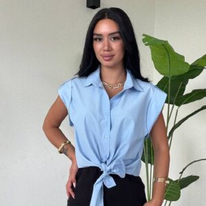Toma de medio cuerpo de una blusa azul cielo con nudo frontal combinada con una falda negra mini ajustada. - Mayoreo Turquía