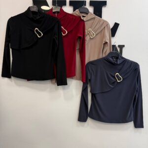 Hanging view of three draped tops showing hems and long sleeves in olive, white and navy with soft gathered shoulders.