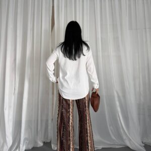 Rueckansicht: strukturierte weiße Bluse mit Langarm, hoch taillierte gemusterte Wide-Leg Hose und braune Tragetasche. Großhandel Türkei erhältlich. - Großhandel Türkei