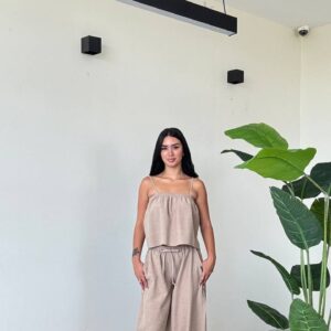 Modelo en conjunto beige relajado de dos piezas con top fruncido, pantalones globo con cordón y tacones blancos - Mayoreo Turquía
