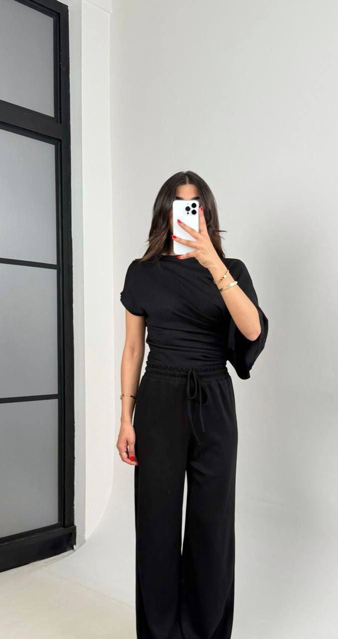 Schwarzes asymmetrisches Set 4821 - Türkei Großhandel Model trägt schwarzes asymmetrisches Draped-Top mit geraffter Taille und weiten Hosen mit Kordelzug. Türkei-Großhandel.