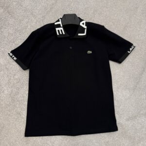 Flat-lay front view of black cotton piqué polo with contrasting knit collar and small embroidered logo at chest. available for wholesale in Turkey.
