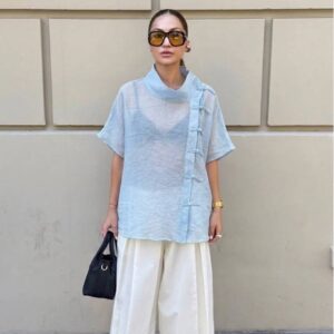 Modelo con top de lino azul claro translúcido, cuello mandarina y ribete de botones de nudo, combinado con pantalones anchos blancos - Mayorista Turquía