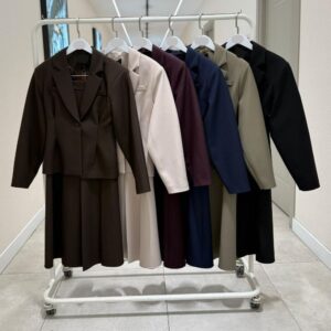 Percha de ropa mostrando conjuntos de blazer y falda en marrón, crema, burdeos, azul marino, taupe y negro en perchas - mayorista-turquia.