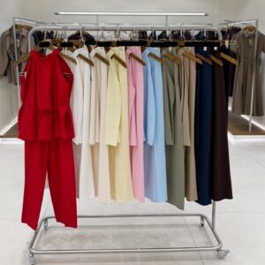 Percha de ropa mostrando conjuntos halter y pantalón en varios colores sobre perchas de madera. - Mayorista Turco