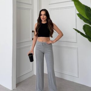 Vorneansicht grau-weite Loungehose mit elastischem Bund und Bindeband, kombiniert mit schwarzem Crop-Top und Sneakern. - Großhandel Türkei