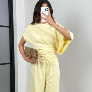 Weiches zitronengelbes Draped-Top mit geraffter Seite und passender lockerer Weitbein-Hose; dazu neutrale Clutch. Türkei-Großhandel.