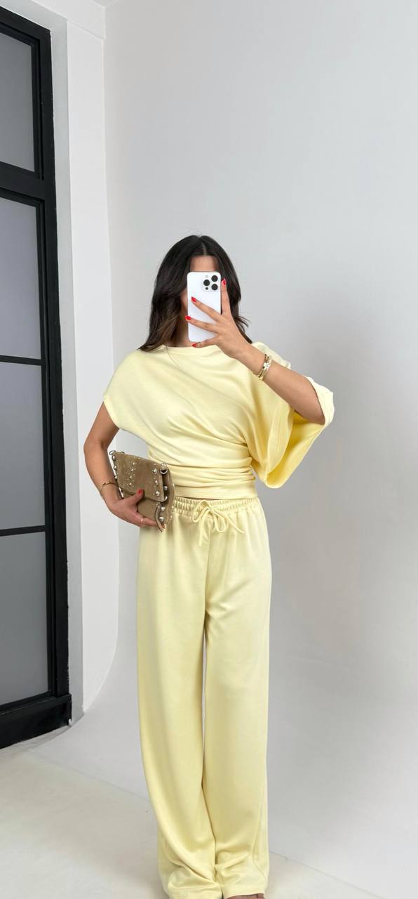 Zitronengelbes drapiertes Set 2057 – Türkei Großhandel Weiches zitronengelbes Draped-Top mit geraffter Seite und passender lockerer Weitbein-Hose; dazu neutrale Clutch. Türkei-Großhandel.