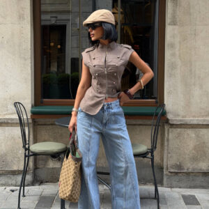 Vista frontal de top militar marrón sin mangas con cremallera, vaqueros anchos lavados claros, gorra beige y bolso monograma. - Mayorista Turquía