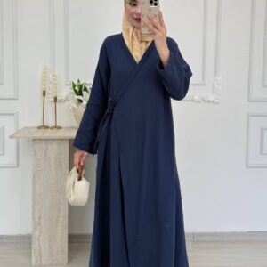 Tiefes Marineblau texturierte Wickel-Abaya mit seitlichem Bindeband und geraden Ärmeln, kombiniert mit cremefarbenem Hijab und kleinem weißen Täschchen. Großhandel Türkei verfügbar.