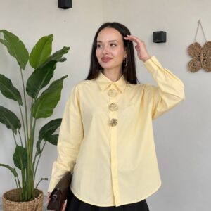 Model fi qamis lawn asfar bayd yuhawwil thalath azrar zahabiya mutasila wa mini skirt aswad wa clutch bunadi. - B2B Turkiya