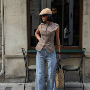 Straßenbild eines gestylten, ärmellosen Militär-Tops, hell gewaschene Weite-Jeans, Sonnenbrille und Monogramm-Tasche. Großhandel Türkei.