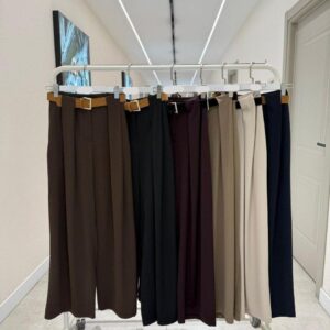 Kleiderständer zeigt plissierte Hochbund-Weite-Hosen in Braun, Schwarz, Burgunder, Beige und Navy, jeweils mit beigem Gürtel. Türkei-Großhandel