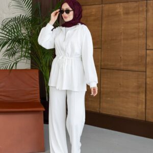 Vollständige Länge der weißen Reißverschluss-Jacke und der plissierten Hose; Model mit dunklem Hijab und Sonnenbrille.