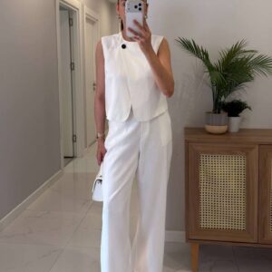 Mirror selfie of white sleeveless tailored vest with black button and matching wide-leg trousers. available for wholesale in Turkey.