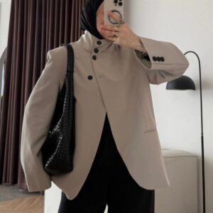 سيلفي أمام المرآة لجاكيت-beige عالي الرقبة مع إغلاق أزرار غير متماثلة و حقيبة كتف black. متاح للشراء بالجملة من تركيا.