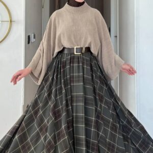 Front view of a beige batwing sweater and dark gray plaid maxi skirt, shown spread wide.