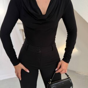 عرض مقرب لبلوزة سوداء بأكمام طويلة تُظهر ياقة منسدلة وفتحة كتف مجمَّعة مع معدن ذهبي. - تجارة جملة تركيا