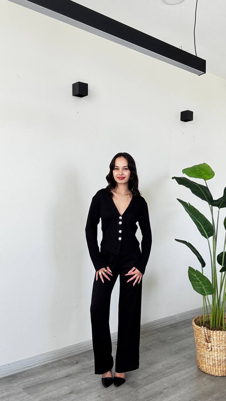 cardigan-negro-pantalones-detalle-9146 – Mayorista en Turquía Cardigan negro con botones y pantalones a juego vistos de frente, con las manos en las caderas. - Mayorista en Turquía