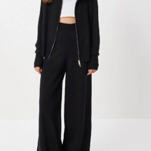 Modelo con chaqueta de punto negra con cremallera frontal y pantalones de pierna ancha a juego. Mayorista Turquía.