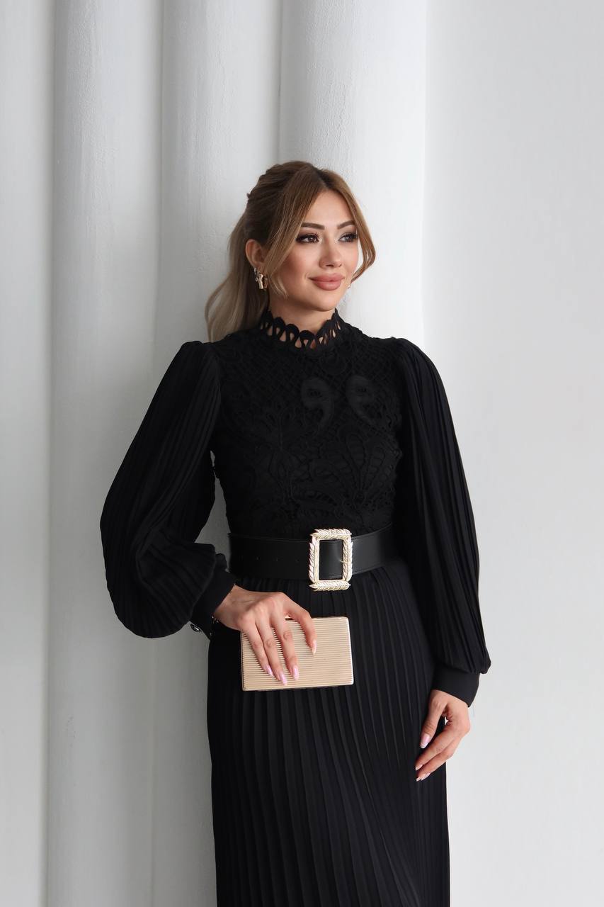 schwarz-spitzen-oberteil-plissee-8371 - Großhandel Türkei Nahaufnahme eines schwarzen Kleides mit filigranem Spitzenoberteil, durchsichtigen Illusionshals und plissierten Ballonärmeln; beigefarbene Clutch in der Hand. Großhandel Türkei erhältlich.