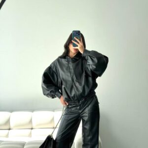 Mirror selfie of black faux-leather bomber with voluminous sleeves and wide-leg faux-leather pants.