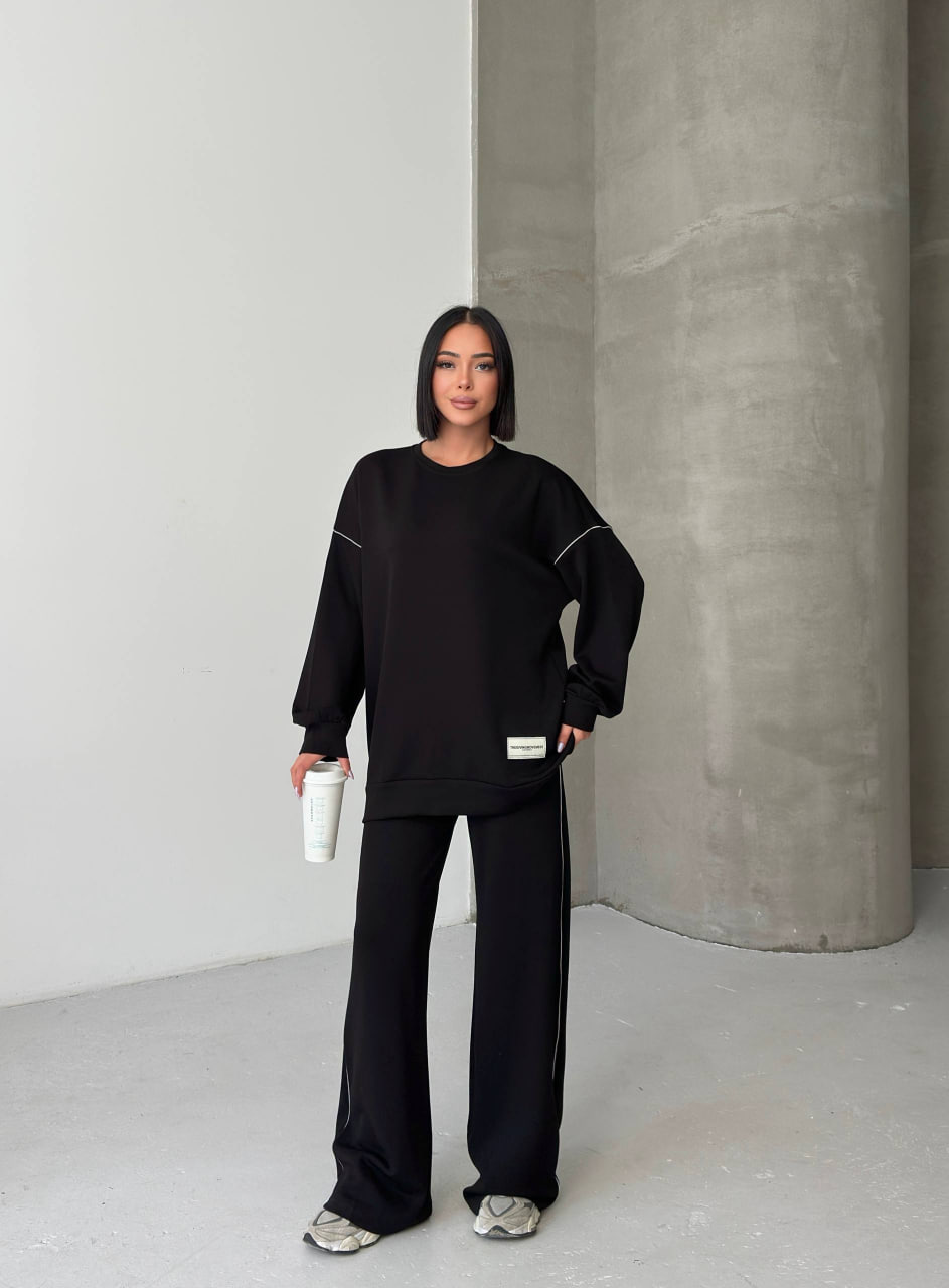 tqm-bkhyt-black-set-7364 Black هودي فضفاض وبنطال واسع الساق مع خطوط خيط رفيعة على الكتفين والساقين.