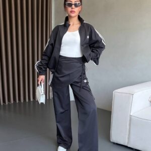 Front view of a dark zip jacket worn open over a white tank, paired with loose matching trousers. available for wholesale in Turkey.