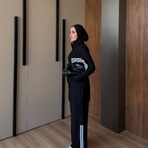 Seitliche Ansicht einer schwarzen langen Tunika und weite Hose mit weißen Streifen an Ärmeln und Beinen. - Großhandel Türkei