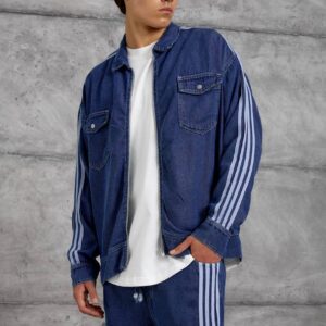 Blue denim jacket shown close up, with a front zipper, buttoned flap pockets, and pale sleeve stripes.