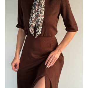 Close side view of brown ribbed knit skirt with thigh-high side slit and fitted waist, hand resting on hip.