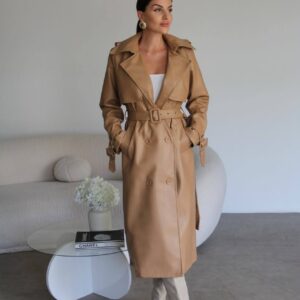 Modelo con una gabardina larga color camel de doble botonadura, solapas anchas, cinturón a juego y correas en los puños. - Mayorista Turquía