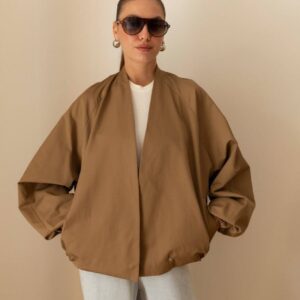 Camel-brown open-front jacket with oversized sleeves, worn over a white top and pale jeans.