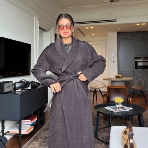 Full-length view of a charcoal textured coat with wide lapels, long sleeves, and a tied waist belt available for wholesale in Turkey.