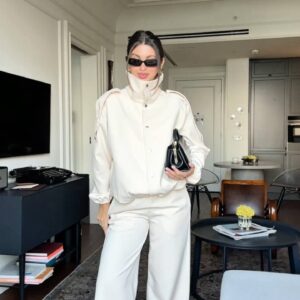 Vista frontal de una chaqueta crema con cuello alto y pestañas en los hombros, y pantalón ancho a juego. - Turquia Mayorista
