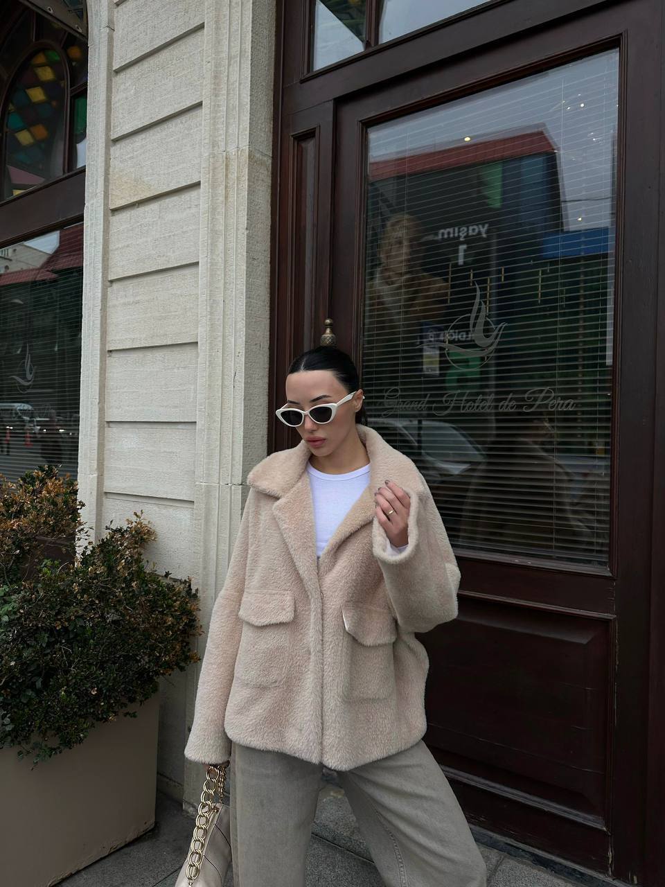 Chaqueta teddy crema 4827 - Mayorista en Turquía Vista exterior de abrigo teddy crema con cuello oversize, bolsillos con solapa y gafas cat-eye. - Mayorista en Turquía