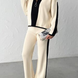 Three-quarter front view of cream knit tracksuit with central black panel, side stripe and zipper pull ring. available for wholesale in Turkey.