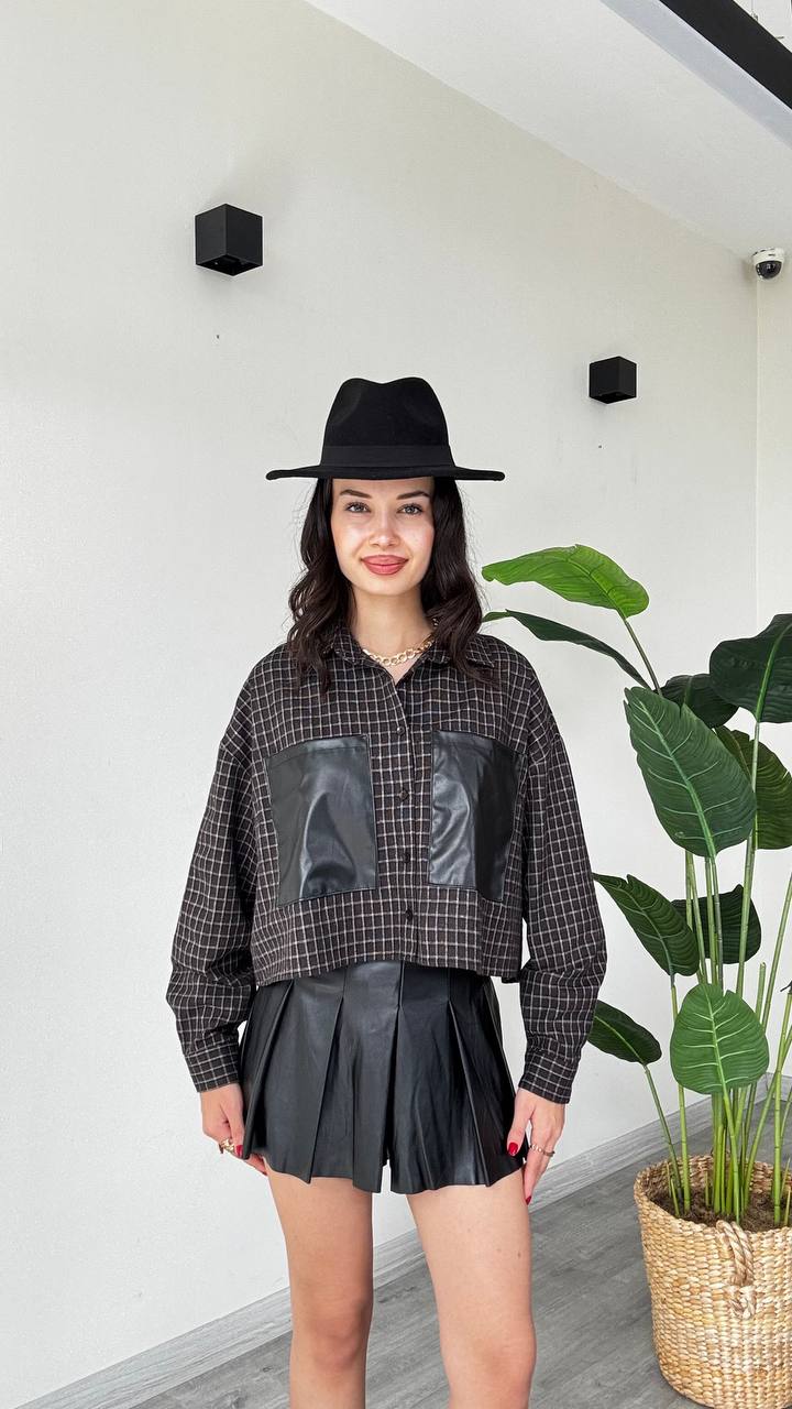 muqta3-plaid-shirt-usloob-4308-turkiya-bil-jumla عارض يرتدي قميص مقطع بنقشة داكنة بأزرار مع أكمام طويلة وجيبين أمامييْن من جلد اصطناعي أسود.